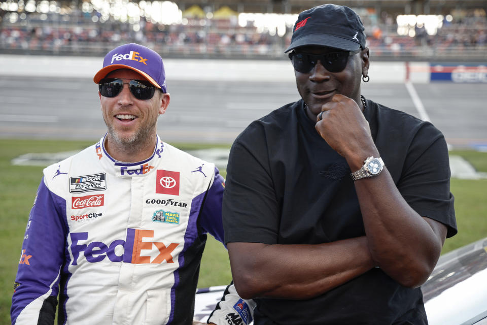 TALLADEGA, ALABAMA - OCTOBER 06: Co-owners of 23XI Racing, Denny Hamlin, driver of the #11 FedEx One Rate Toyota, and NBA Hall of Famer, Michael Jordan talk on the grid after the NASCAR Cup Series YellaWood 500 at Talladega Superspeedway on October 06, 2024 in Talladega, Alabama. (Photo by Chris Graythen/Getty Images)