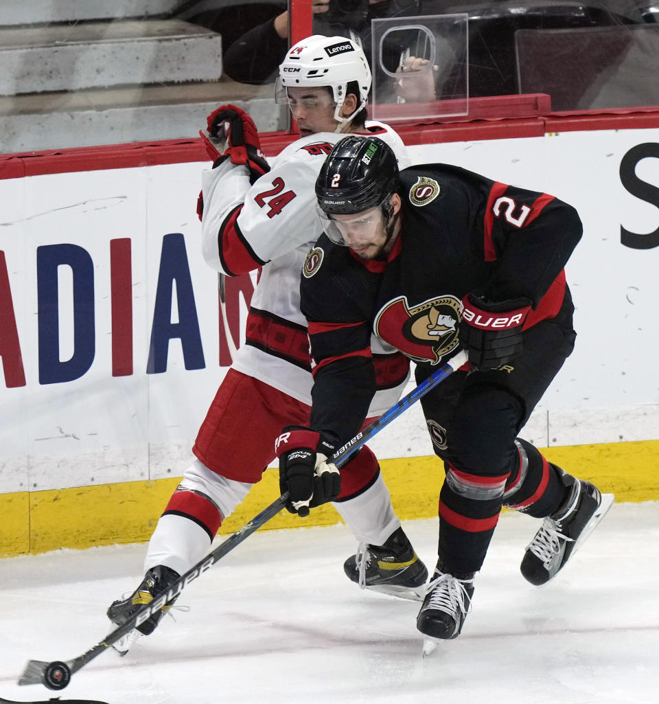 Ottawa Senators defenseman Artem Zub battles for control of the puck with Carolina Hurricanes center Seth Jarvis during the first period of an NHL hockey game, Thursday, Jan. 27, 2022 in Ottawa, Ontario. (Adrian Wyld/The Canadian Press via AP)