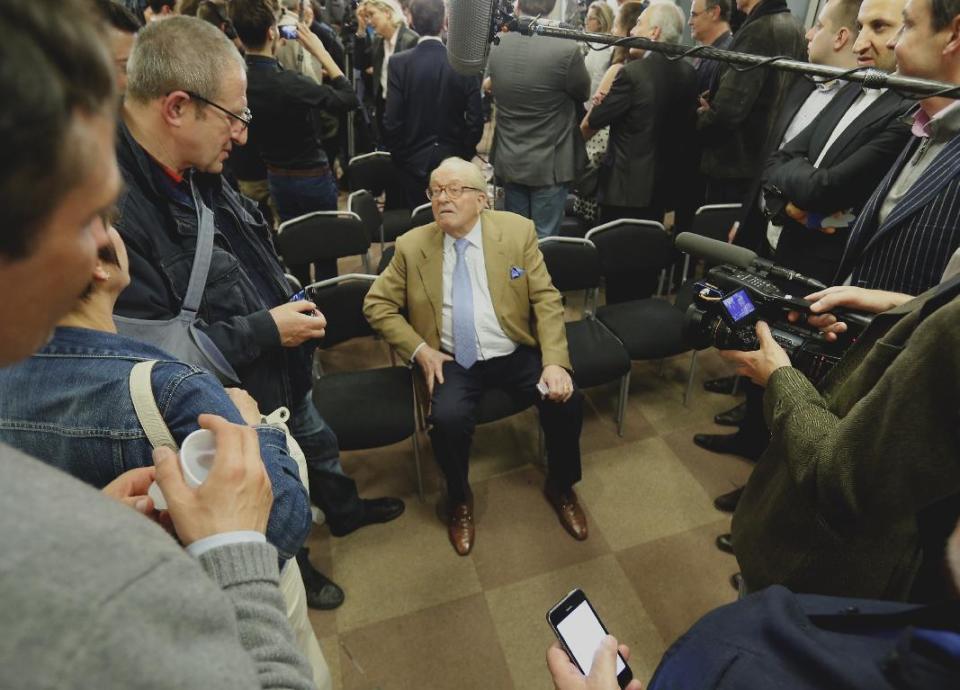 The former leader of France's far right National Front party Jean-Marie Le Pen, center, speaks with members of the media at the party headquarters in Nanterre, west of Paris, Sunday, March 30, 2014. French pollsters say the governing Socialists lost ground to the conservative right in municipal elections Sunday that are seen as a referendum on embattled President Francois Hollande and certain to lead to a government shakeup. Estimates showed the anti-immigration far right adding several towns to its victory bucket after a symbolic win in the northern town of Henin-Beaumont in last week’s first round. (AP Photo/Jacques Brinon)