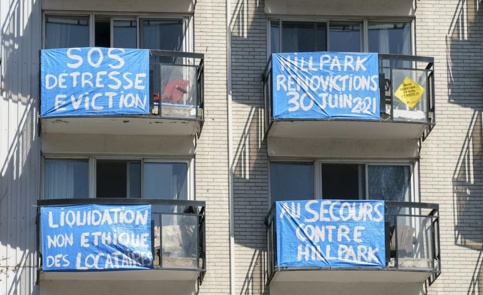 Banners are seen on the balconies of an apartment building where residents received notices stating they must move out for at least seven months due to renovations in Montréal in April 2021. THE CANADIAN PRESS/Paul Chiasson