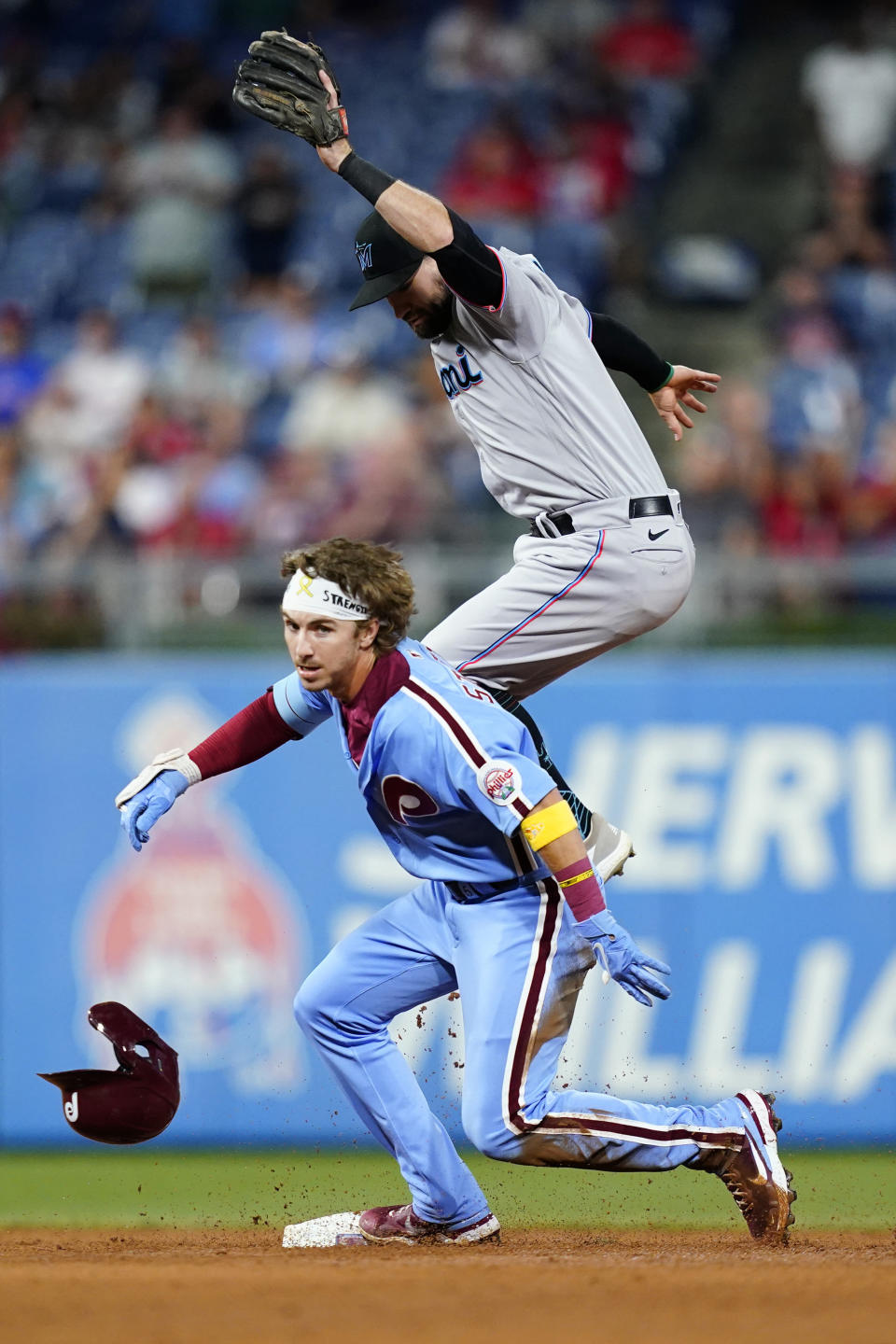 Philadelphia Phillies' Bryson Stott, left, slides under Miami Marlins second baseman Jon Berti on a run-scoring double during the fourth inning of a baseball game, Thursday, Sept. 8, 2022, in Philadelphia. (AP Photo/Matt Slocum)