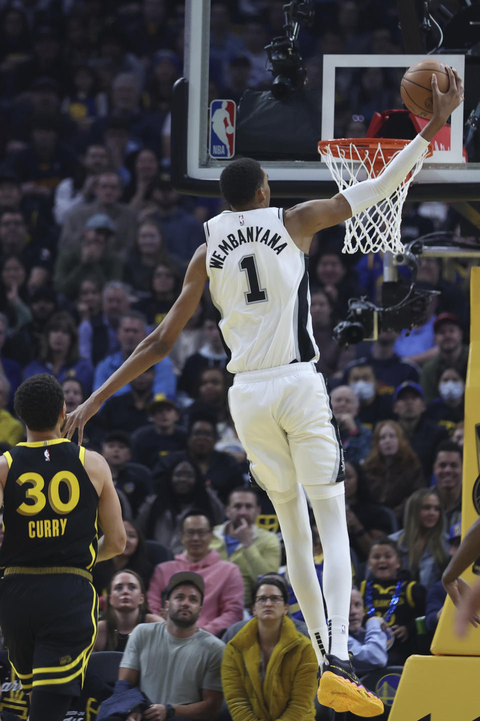 San Antonio Spurs center Victor Wembanyama (1) dunks against Golden State Warriors guard Stephen Curry (30) during the first half of an NBA basketball In-Season Tournament game in San Francisco, Friday, Nov. 24, 2023. (AP Photo/Jed Jacobsohn)