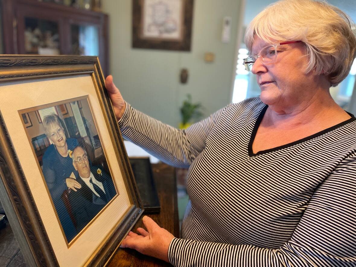 Brenda MacLean looks at a photo of herself and husband Lawrence.  (Steve Bruce/CBC - image credit)