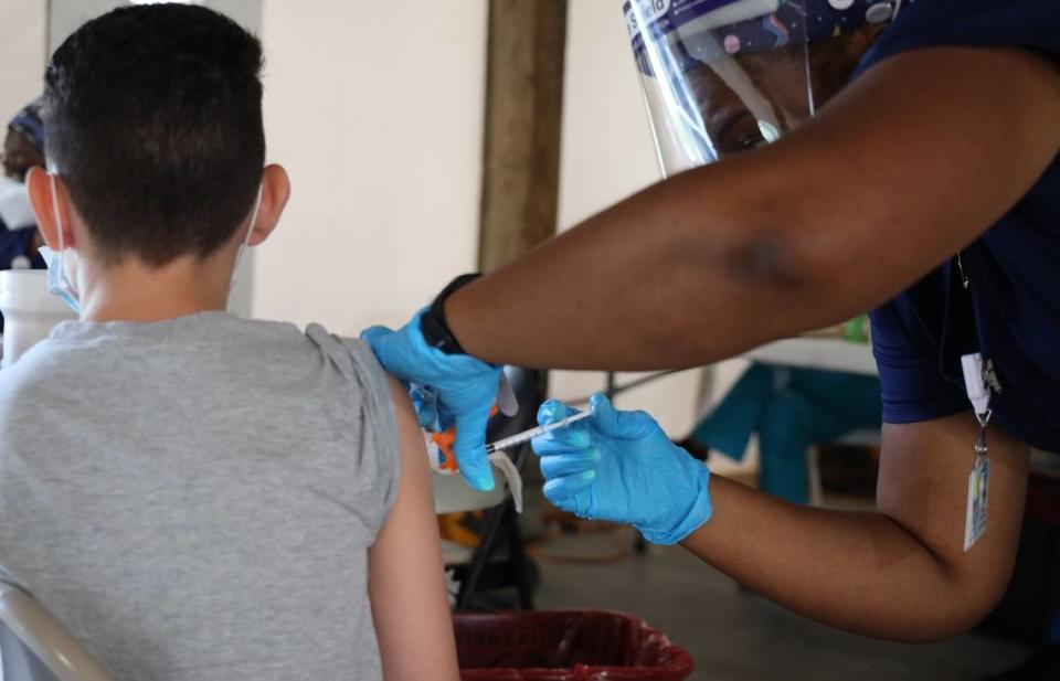 In this Aug. 9, 2021 photo, a 14-year-old boy gets his first COVID-19 vaccine shot at C.B. Smith Park in Pembroke Pines. The vaccination event was a partnership between the Florida Department of Health, Broward County and the City of Pembroke Pines.