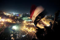 FILE - In this Jan. 25, 2012 file photo, people wave flags in Tahrir Square to mark the first anniversary of the popular uprising that led to the quick ouster of autocrat President Hosni Mubarak, in Cairo, Egypt. A decade later, thousands are estimated to have fled abroad to escape a state, headed by President Abdel Fattah el-Sissi, that is even more oppressive. (AP Photo/Amr Nabil, File)