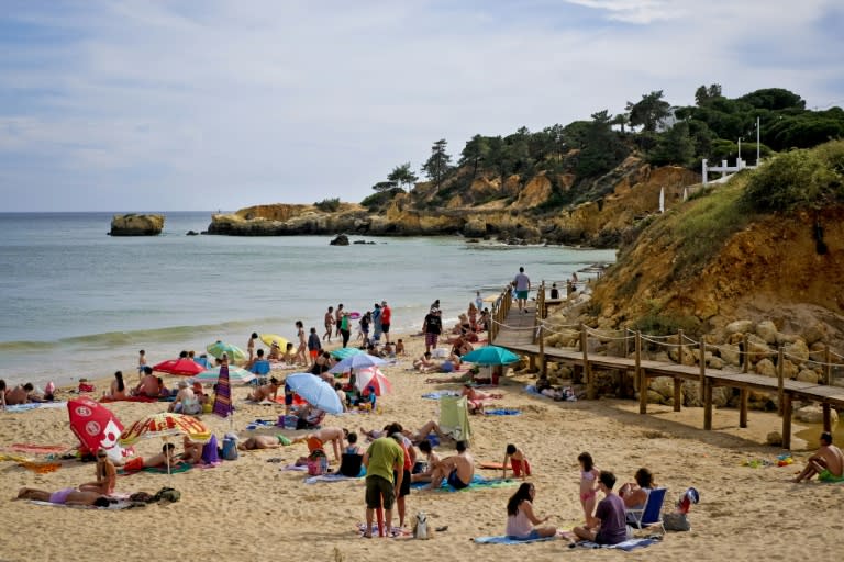 People sunbath on Santa Eulalia beach at Albufeira, Loule, southern Portugal on June 10, 2016