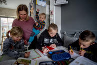 Katja Heimann helps her children with studies in their home in Eisemroth, central Germany, Thursday, March 25, 2021. One year into the coronavirus pandemic, Katja Heimann is still trying to keep her spirits up - despite several lockdowns and months of teaching seven of her children in home schooling. (AP Photo/Michael Probst)