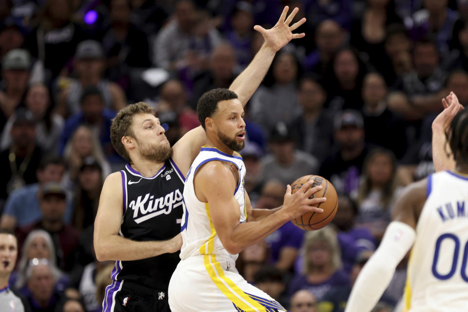 Golden State Warriors guard Stephen Curry drives to the basket against Sacramento Kings forward Sasha Vezenkov, left, during the first half of an NBA basketball game in Sacramento, Calif, Friday, Oct. 27, 2023. (AP Photo/Jed Jacobsohn)