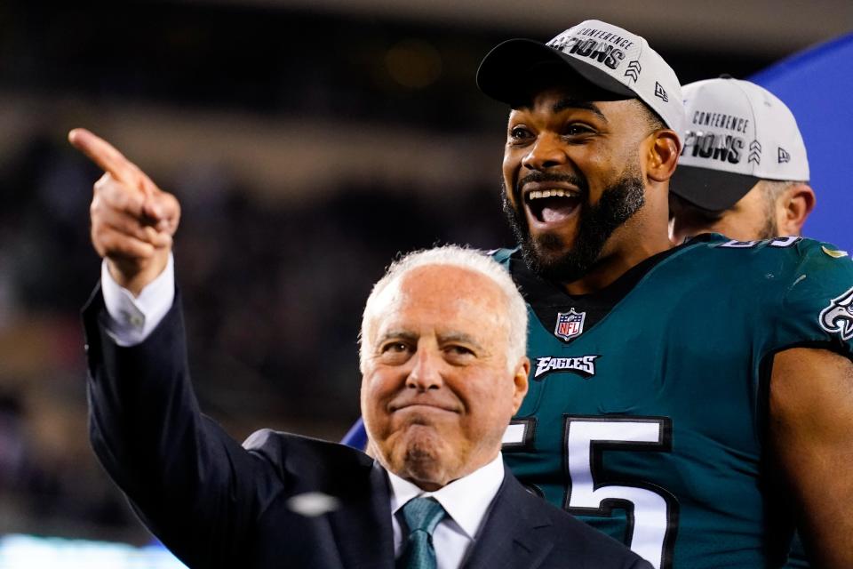 Philadelphia Eagles owner Jeffrey Lurie, left, gestures while standing on stage with defensive end Brandon Graham after the NFC championship game between the Philadelphia Eagles and the San Francisco 49ers on Sunday, Jan. 29, 2023, in Philadelphia. The Eagles won 31-7.