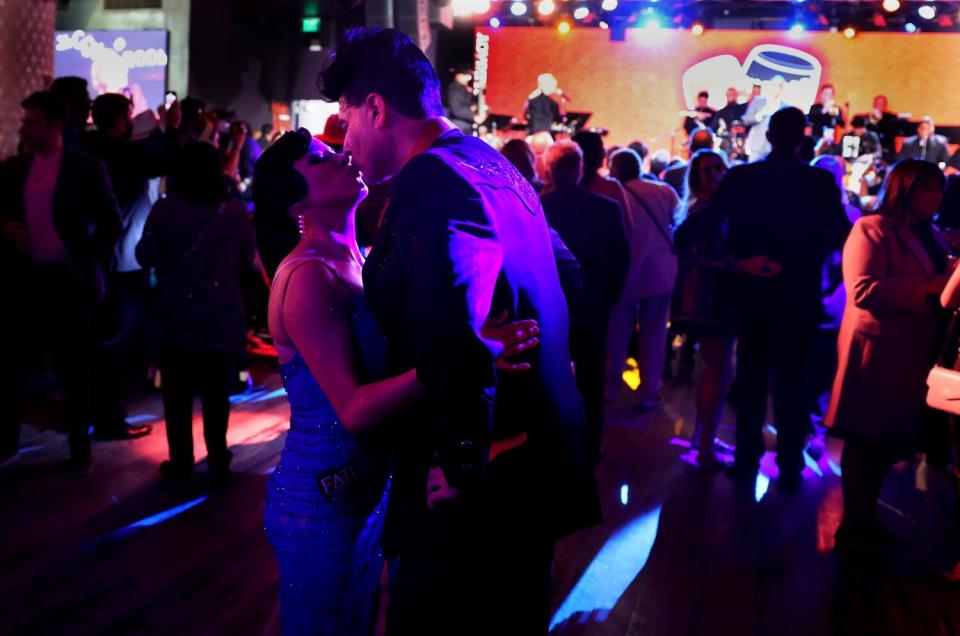 Dancers kiss on the dance floor.