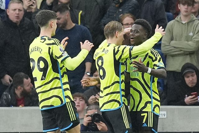 Bukayo Saka, right, celebrates his opener against Brighton with Martin Odegaard, centre, and Kai Havertz