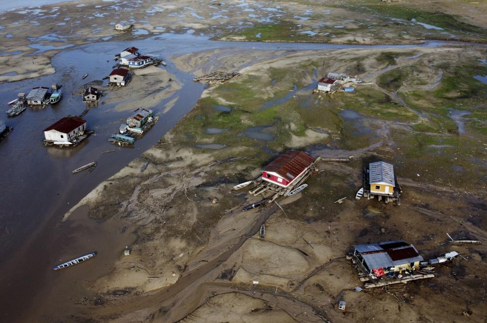 FILE - Houseboats sit amid drought-impacted land near the Solimões River, in Tefe, Amazonas state, Brazil, Oct. 19, 2022. The two-day Amazon Summit opens Tuesday, Aug. 8, 2023, in Belem, where Brazil hosts policymakers and others to discuss how to tackle the immense challenges of protecting the Amazon and stemming the worst of climate change. (AP Photo/Edmar Barros, File)