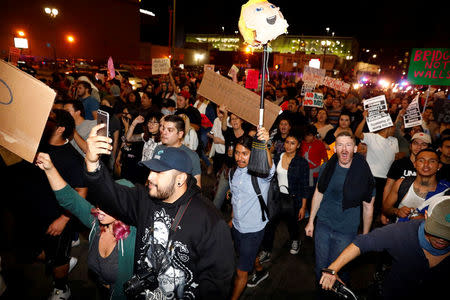 A demonstrator holds a pinata head of Donald Trump on a stick as they march in protest through the streets of downtown Los Angeles in protest following the election of Republican Donald Trump as President of the United States in Los Angeles, California November 10, 2016. REUTERS/Patrick T. Fallon TEMPLATE OUT