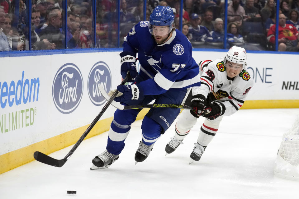 Tampa Bay Lightning defenseman Victor Hedman (77) beats Chicago Blackhawks center Connor Bedard (98) to a loose puck during the first period of an NHL hockey game Thursday, Nov. 9, 2023, in Tampa, Fla. (AP Photo/Chris O'Meara)