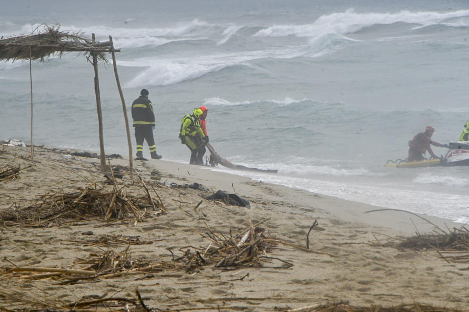 Rescuers recover a body at a beach near Cutro, southern Italy, after a migrant boat broke apart in rough seas on Sunday, Feb. 26, 2023. Nearly 70 people died in last week's shipwreck on Italy's Calabrian coast. The tragedy highlighted a lesser-known migration route from Turkey to Italy for which smugglers charge around 8,000 euros per person. (AP Photo/Giuseppe Pipita, File)