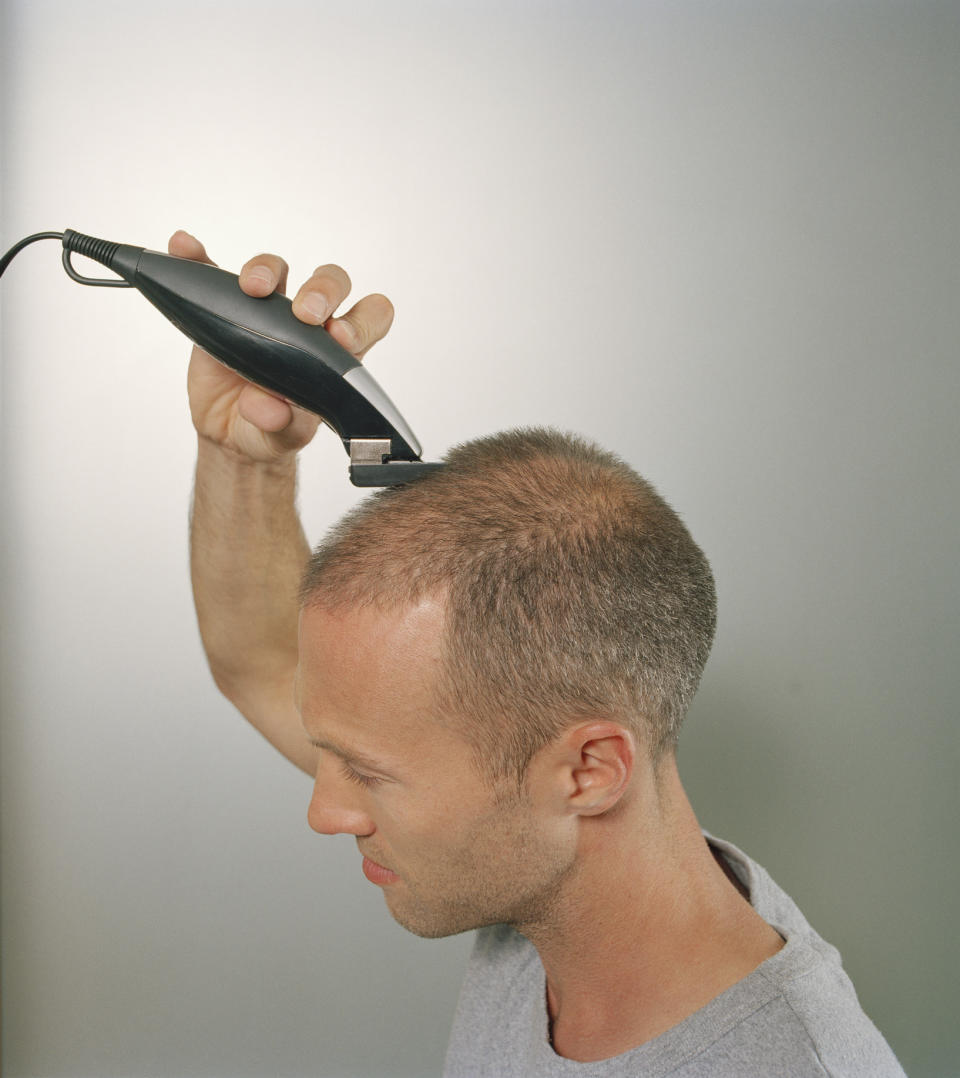 A man shaving his own head