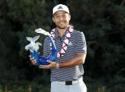 Xander Schauffele holds the champions trophy after the final round of the Tournament of Champions golf event, Sunday, Jan. 6, 2019, at Kapalua Plantation Course in Kapalua, Hawaii. (AP Photo/Matt York)