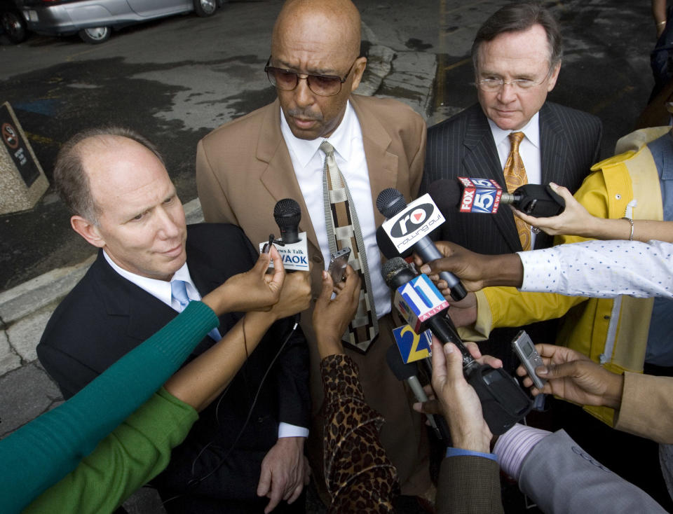 Attorney Dwight Thomas, center, speaks to reporters alongside two colleagues outside the federal courthouse in Atlanta after a bond hearing for their client, rapper T.I., on Oct.19, 2007. / Credit: John Amis / AP