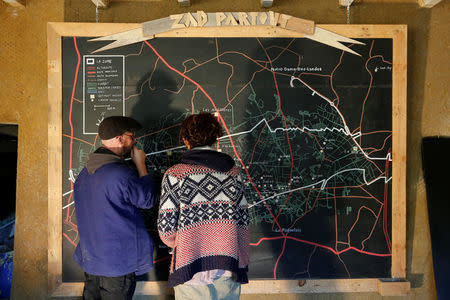 Residents looks at a map at "La Rolandiere" area in the zoned ZAD (Deferred Development Zone) in Notre-Dame-des-Landes, that is slated for the Grand Ouest Airport (AGO), western France, October 17, 2016. REUTERS/Stephane Mahe