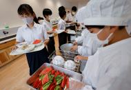 Students receive school lunch at Senju Aoba Junior High School in Tokyo