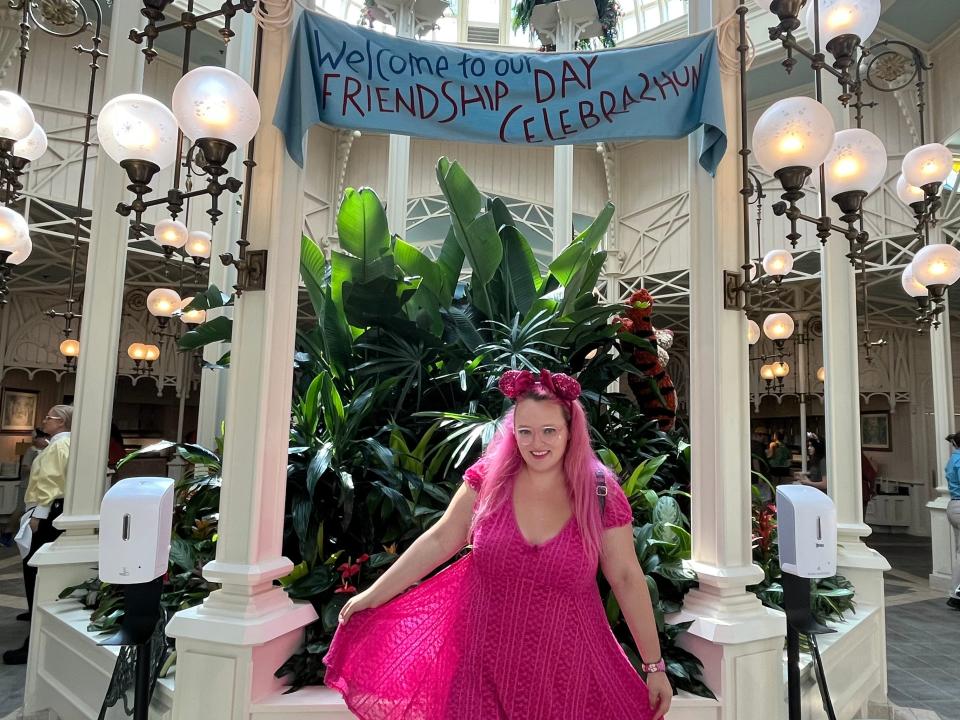 Author standing in front of topiary with celebration banner hanging above.