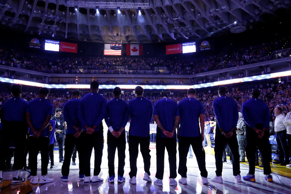 Members of the Golden State Warriors stand during the national anthem before their NBA pre-season game against the Denver Nuggets at Oracle Arena in Oakland, California, U.S., September 30, 2017. REUTERS/Stephen Lam