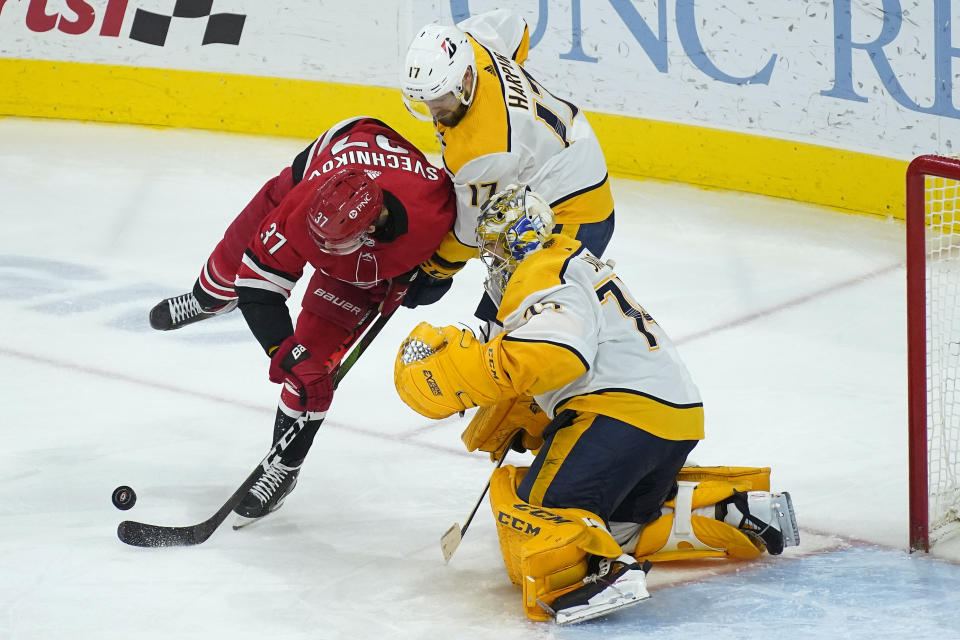 Carolina Hurricanes right wing Andrei Svechnikov (37) tries to score against Nashville Predators goaltender Juuse Saros (74) while defenseman Ben Harpur (17) defends during the third period of an NHL hockey game in Raleigh, N.C., Saturday, April 17, 2021. (AP Photo/Gerry Broome)