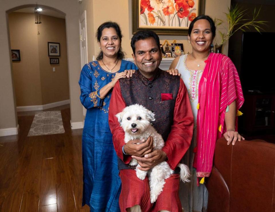 Folsom City Council member YK Chalamcherla holds the family dog, Teddy, as he sits with his wife Aparna Throvagunta, left, and daughter, Tejasvi Chalamcherla, at their home in Folsom on Tuesday. He ultimately decided to settle down with his family in Folsom after leaving India in 1998.