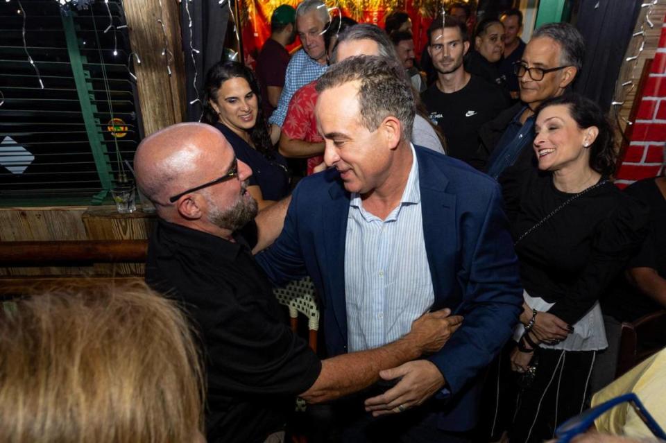 Commissioner-elect Damian Pardo is embraced by Ball & Chain owner Bill Fuller as he reacts to to the news of unseating incumbent commissioner Sabina Covo during a runoff election watch party for Miami District 2 commission seat at Flanigan’s in Miami, Florida, on Tuesday, November 21, 2023.