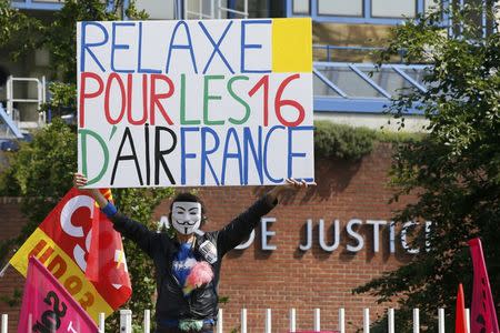 A man holds a placard that reads ''Don't sentence the 16 Air France employees'' as French CGT labour union members gather at the start of the trial of Air France employees near the courthouse in Bobigny, France, May 27, 2016. REUTERS/Gonzalo Fuentes