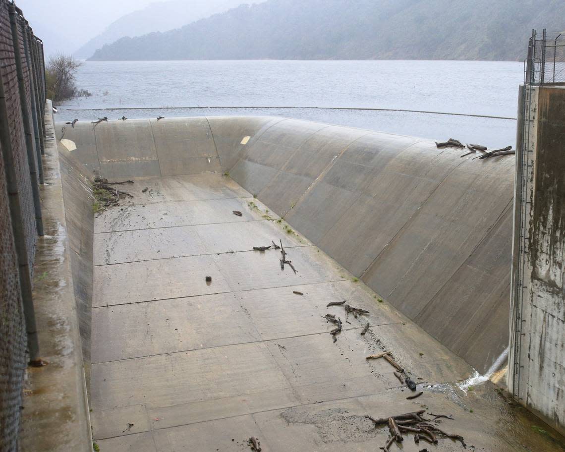 Lopez Lake trickles over its spillway on Feb. 7, 2024, after atmospheric river storms dumped several inches of rain on the reservoir’s watershed.