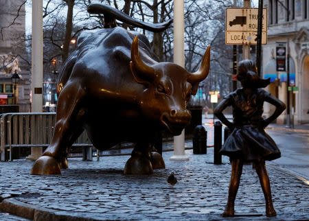 A statue of a girl facing the Wall St. Bull is seen, as part of a campaign by U.S. fund manager State Street to push companies to put women on their boards, in the financial district in New York, U.S., March 7, 2017. REUTERS/Brendan McDermid