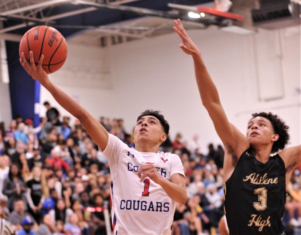 Andrew Gonzalez (1) drives to the basket as Abilene High's Hayden Williams (3) defends in the first quarter. Cooper beat the Eagles 56-46 in the nondistrict game Friday, Dec. 17, 2021, at Cougar Gym.