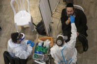 Medical personnel test a passenger for coronavirus on his arrival in Israel, at Ben Gurion Airport near Tel Aviv, Israel, Sunday, Jan. 24, 2021, during a nationwide lockdown to curb the spread of the COVID-19 virus. (AP Photo/Ariel Schalit)