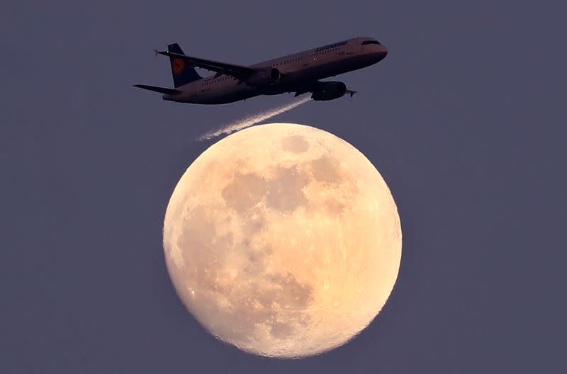 FILE PHOTO: An airplane of German air carrier Lufthansa passes the moon over Frankfurt