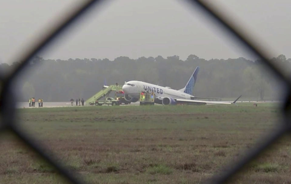 Passengers are evacuated from a United flight at George Bush International Airport, Friday, March 8, 2024 in Houston. Passengers had to be evacuated from the plane after it rolled off a runway and got stuck in the grass. (KTRK via AP)