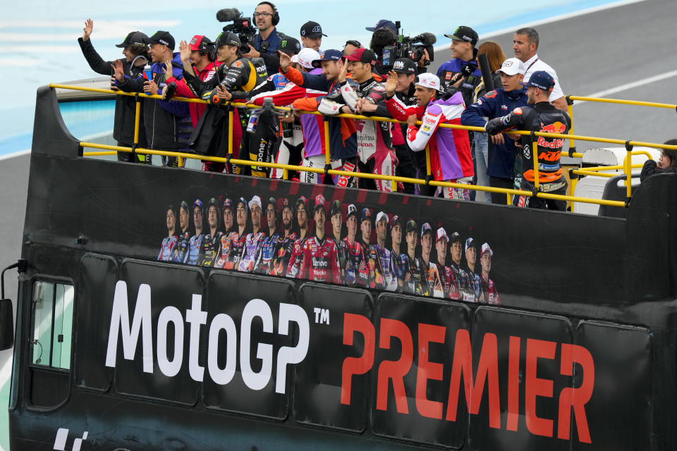 FILE - Moto GP competitors wave from a bus during the Riders Fan Parade at Termas de Rio Hondo circuit in Argentina, Sunday, April 2, 2023. Liberty Media Corp., the American company that owns Formula 1, is adding to its global racing portfolio with the purchase of the MotoGP motorcycle racing series by the end of the year, MotoGP officials announced Monday, April 1, 2024. (AP Photo/Natacha Pisarenko, File)