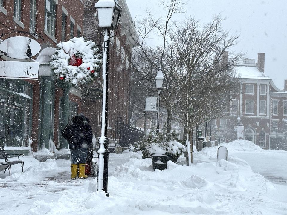 A person clears a sidewalk as snow falls in Portsmouth, N.H., Sunday, Jan. 7, 2024. A major winter storm bringing up to a foot of snow and freezing rain to some communities spread across New England Sunday sending residents scurrying to pull out their shovels and snow blowers to clear sidewalks and driveways. Winter storm warnings and watches were in effect throughout the Northeast, and icy roads made for hazardous travel as far south as North Carolina. (AP Photo/Caleb Jones)