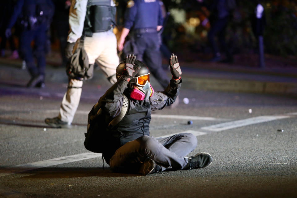 Protesters and police clash during a demonstration, early Thursday, Aug. 13, 2020, in downtown Portland. Officers used tear gas to break up the crowd of several hundred people who gathered near the Mark O. Hatfield U.S. Courthouse, the neighboring Multnomah County Justice Center and a nearby police precinct station. (Sean Meagher/The Oregonian via AP)