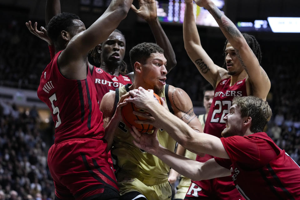 Purdue forward Mason Gillis (0) is surrounded after a rebound by Rutgers players , left to right, Aundre Hyatt Clifford Omoruyi, Caleb McConnell and Cam Spencer during the second half of an NCAA college basketball game in West Lafayette, Ind., Monday, Jan. 2, 2023. Rutgers defeated Purdue 65-64. (AP Photo/Michael Conroy)