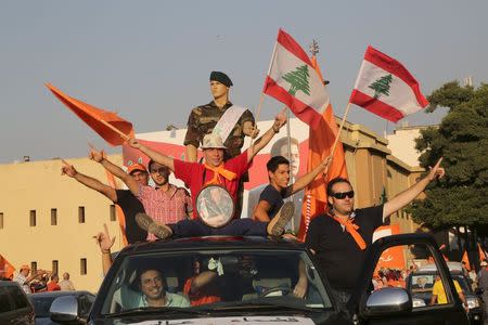 Supporters of the Free Patriotic Movement (FPM) carry flags, a picture of the head of Free Patriotic Movement Michel Aoun, and a mannequin during a protest in Beirut, Lebanon, September 4, 2015. REUTERS/Aziz Taher