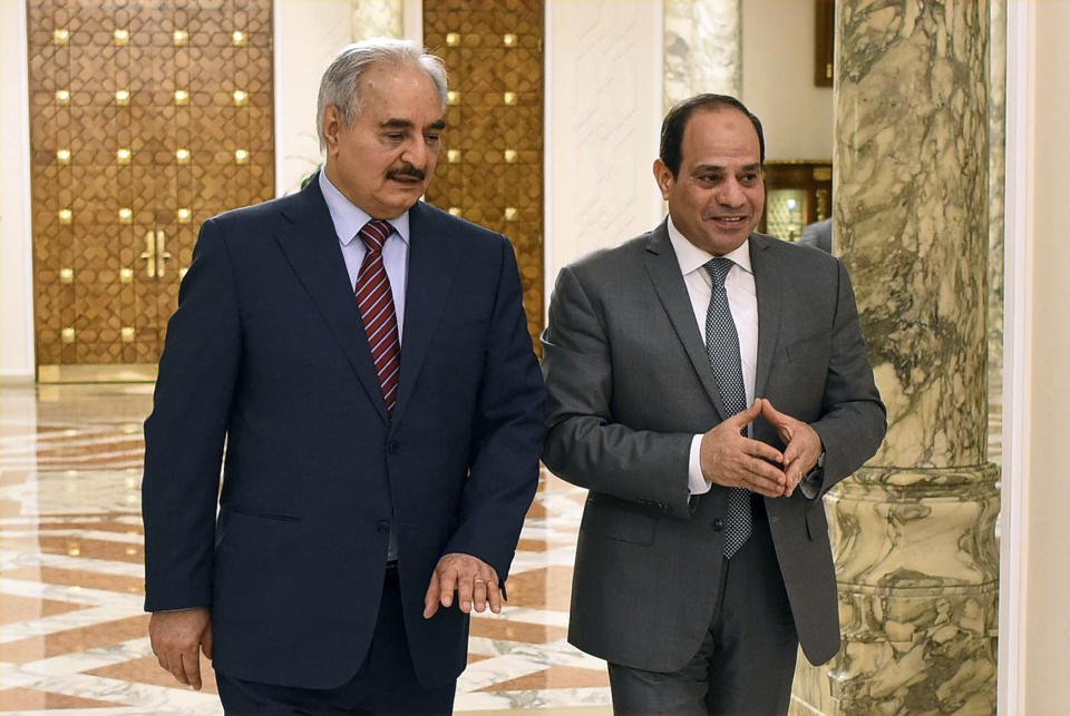 FILE - In this May 9, 2019 file photo, provided by Egypt's presidency media office, Egyptian President Abdel-Fattah el-Sissi, right, walks with military commander Khalifa Hifter, the head of the self-styled Libyan National Army, in Cairo, Egypt. The Egyptian Parliament is likely to vote Monday, July 20, 2020, to authorize the country's president to deploy troops to war-torn Libya if Turkey-backed forces allied with the U.N.-supported government in Tripoli move to retake the strategic coastal city of Sirte. The country is now split between a government in the east, allied with Hifter, and one in Tripoli, in the west, supported by the United Nations. Along with Egypt, Hifter is also backed by the United Arab Emirates and Russia, while the in addition to Turkey, the Tripoli forces are aided by Qatar and Italy. (Egyptian Presidency Media office via AP, File)