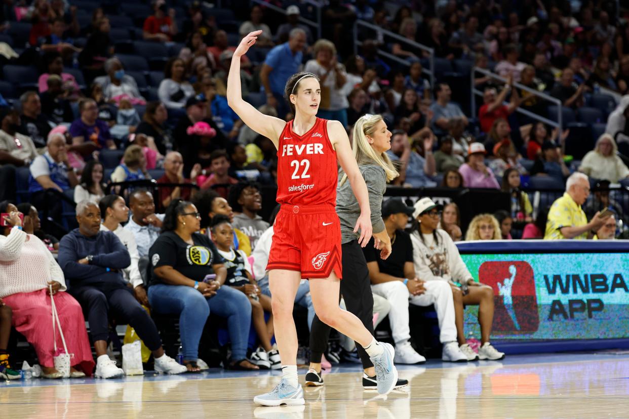 Caitlin Clark encourages the crowd's cheers as she walks off the court in Chicago.