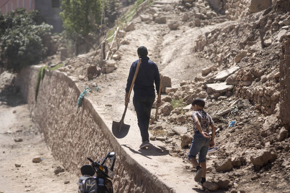 A man carries tools to dig through the rubble of his home, after an earthquake in Moulay Brahim village, near Marrakech, Morocco, Saturday, Sept. 9, 2023. A rare, powerful earthquake struck Morocco late Friday night, killing more than 800 people and damaging buildings from villages in the Atlas Mountains to the historic city of Marrakech. But the full toll was not known as rescuers struggled to get through boulder-strewn roads to the remote mountain villages hit hardest. (AP Photo/Mosa'ab Elshamy)