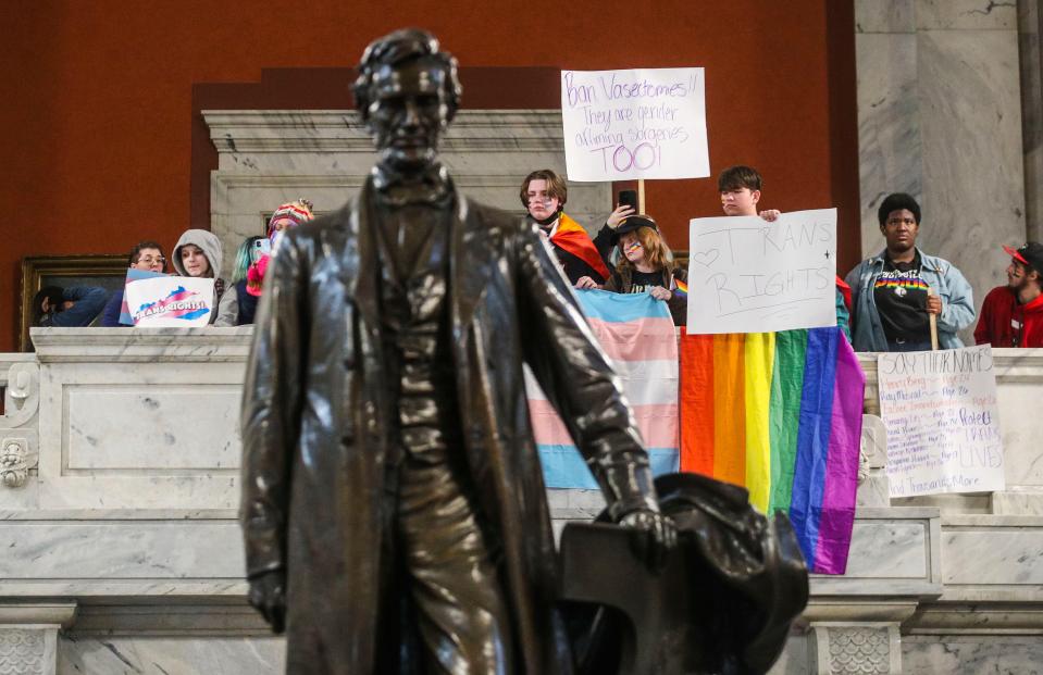 Behind the statue of Abraham Lincoln, students look on at a Family Freedom rally in the capitol rotunda Wednesday. Hundreds of students from throughout Kentucky rallied in Frankfort Wednesday to oppose SB 150, the bill that would ban gender-affirming care for trans youth. March 29, 2023 