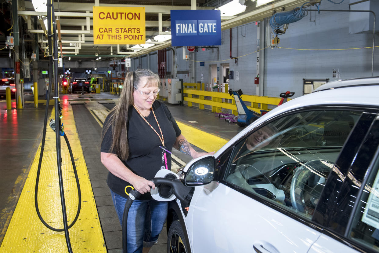 General Motors (GM) team member Kim Fuhr charges a Chevrolet Bolt EUV on the final line of production at Orion Assembly in Lake Orion, Michigan on July 21, 2021. (Photo by Nic Antaya for The Washington Post via Getty Images)
