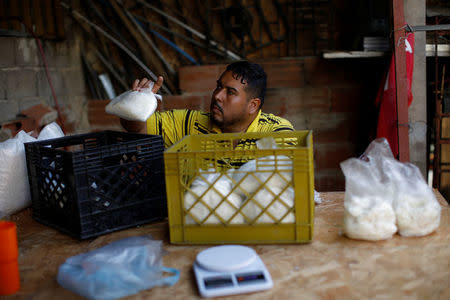 El reparador de equipos médicos, Leandro Colmenares, coloca la masa de maíz en bolsas de plástico en su casa en Caracas, Venezuela, el 3 de octubre de 2017. REUTERS/Carlos Garcia Rawlins