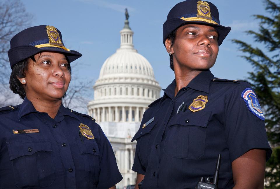 Acting Capitol Police Chief Yogananda Pittman, left, stands next to Monique Moore, right, in 2012 when they were promoted as the first two African-American women to rank of captain on the U.S. Capitol Police force.