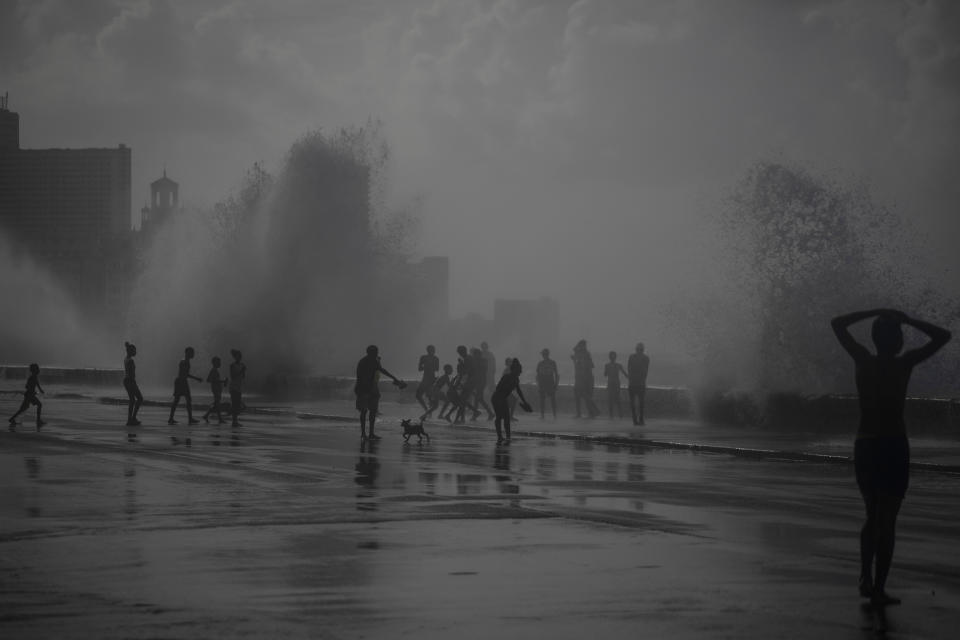 La gente juega en las olas que rompen en el Malecón, después del huracán Ian en La Habana, Cuba, el miércoles 28 de septiembre de 2022. (AP Foto/Ramón Espinosa)