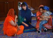 Samantha Cameron (C), wife of Britain's Prime Minister and leader of the Conservative Party, David Cameron, sits with Conservative parliamentary candidate Priti Patel (R), as she joins her husband to take part in the Sikh Vaisakhi Festival at Guru Nanak Darbar Gurdwara in Gravesend, southern England, on April 18, 2015 ahead of the general election on May 7. The Vaisakhi Festival is the most important event in the Sikh calendar and celebrates the birth Khalsa. AFP PHOTO / POOL / PETER MACDIARMID (Photo credit should read PETER MACDIARMID/AFP via Getty Images)